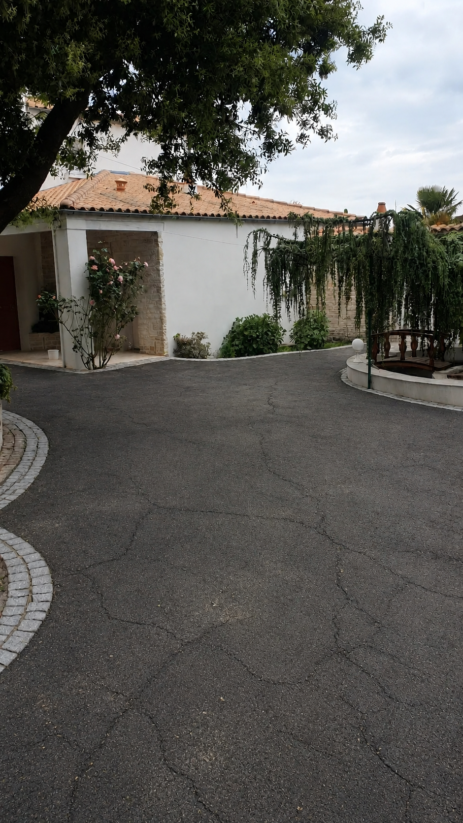 Cour en bitume fissuré et usé avant rénovation