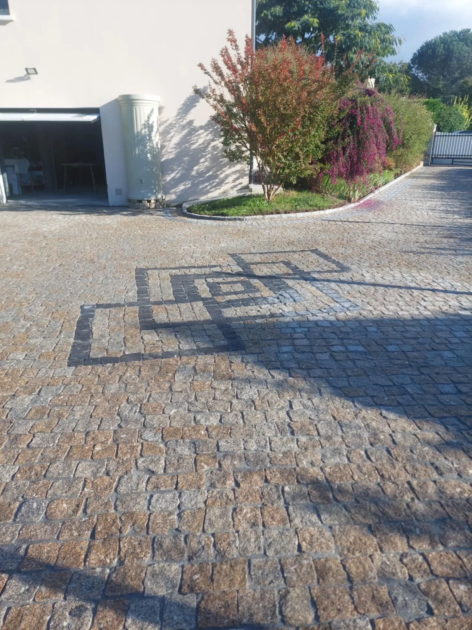 Allée en pavé doré ornée d'une frise géométrique en granit gris